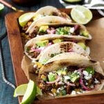 Mexican Lamb Tacos with Tequila Soaked Golden Raisins, Pepitas, and PIckled Onions | sharedappetite.com