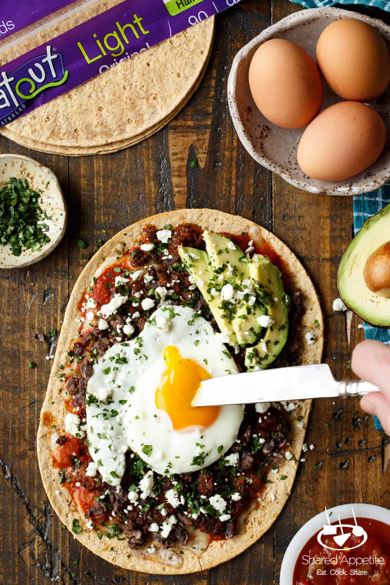 Huevos Rancheros Flatbread Pizza with Monterey Jack Cheese, Salsa, Black Beans, Avocado, and a Fried Egg! sharedappetite.com