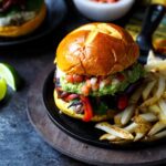 Fajita Burgers with grilled peppers and onions, guacamole, and pico de gallo | sharedappetite.com