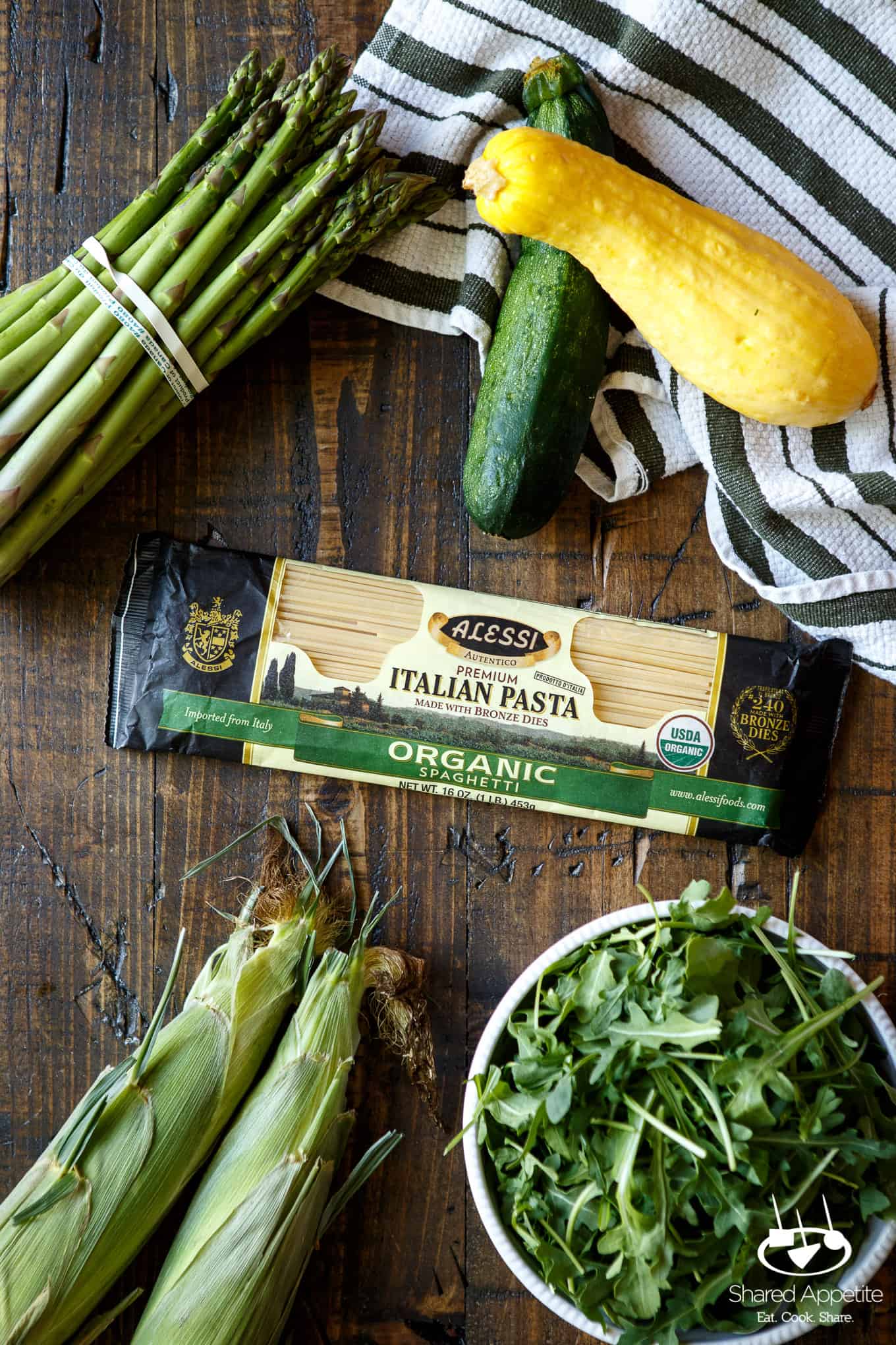 All the ingredients in this Summer Vegetable Pasta with Arugula Pesto, including asparagus, squash, zucchini, spaghetti, corn, and arugula | sharedappetite.com