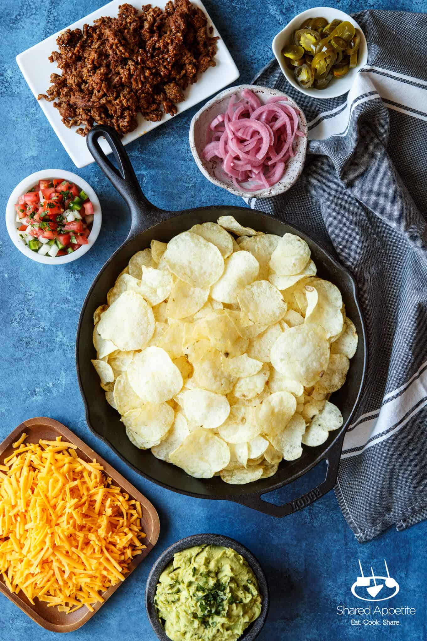 All the components to make these Skillet Loaded Taco Potato Chip Nachos | sharedappetite.com