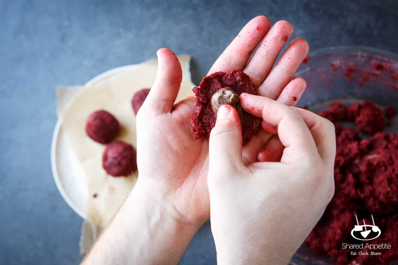 Filling the cake balls with nutella for Nutella Filled Red Velvet Cake Truffles | sharedappetite.com