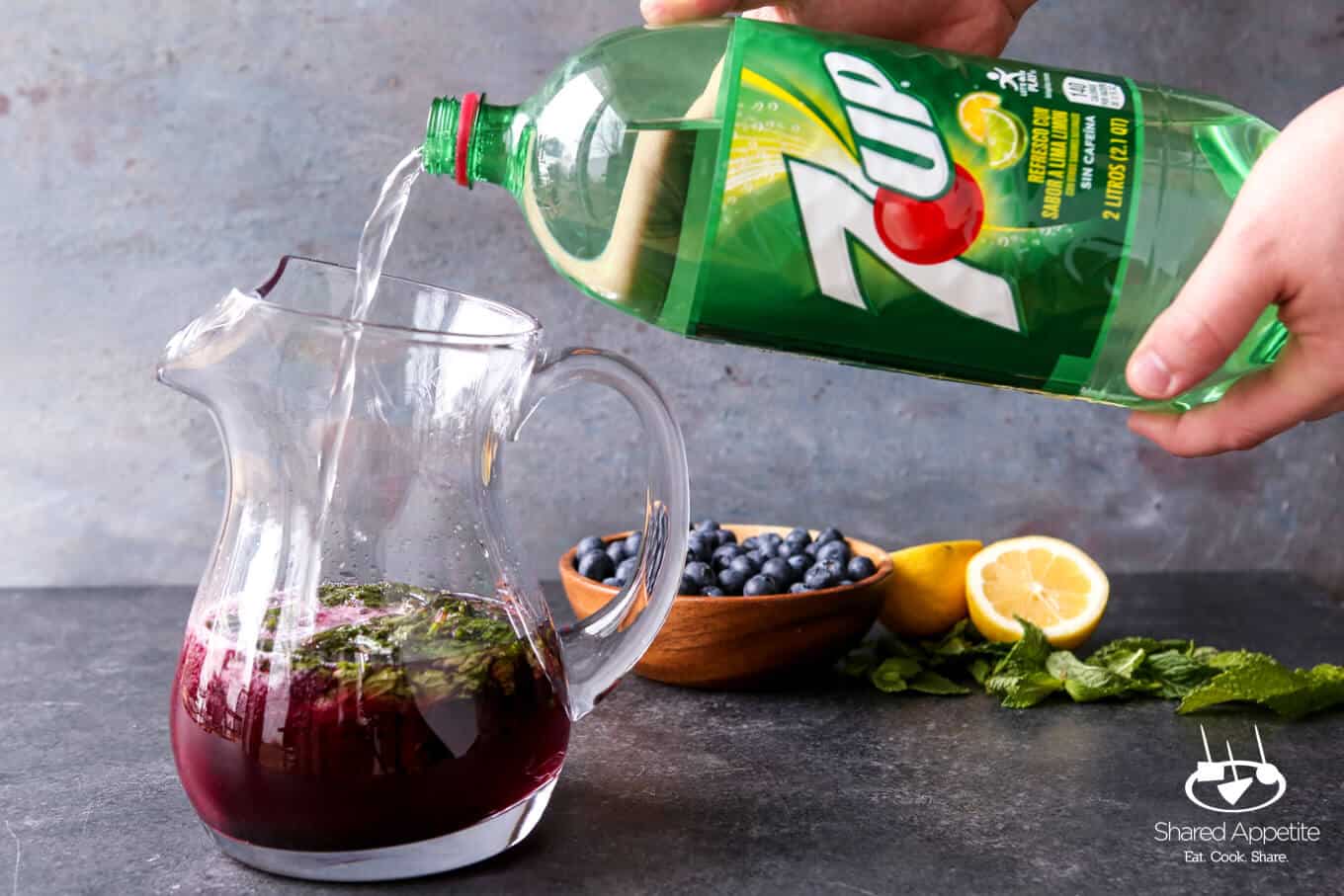 pouring in 7UP into these Sparkling Blueberry Lemonade Mojitos | sharedappetite.com