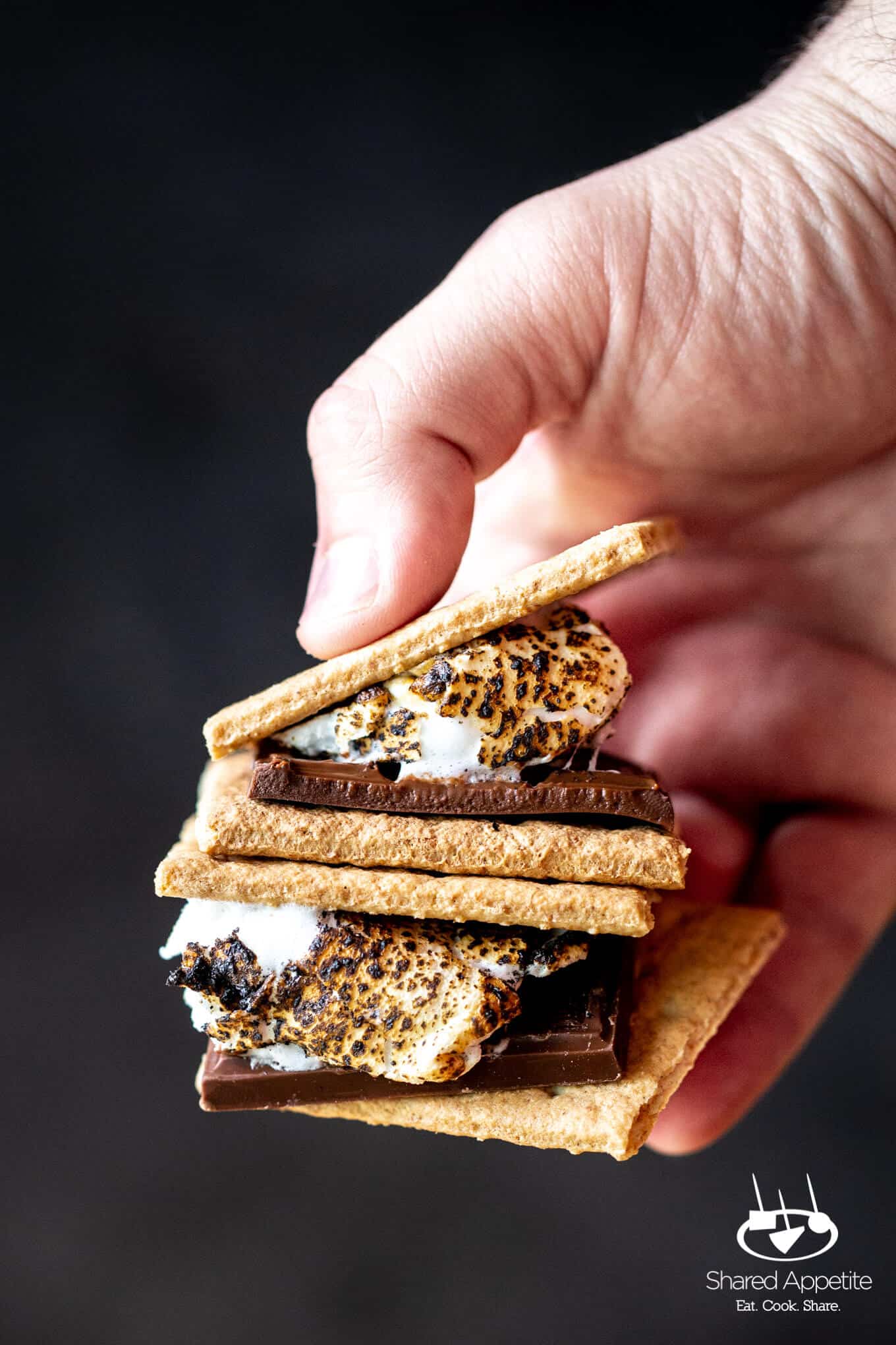 Holding s'mores from DIY S'MORES BAR PARTY | sharedappetite.com