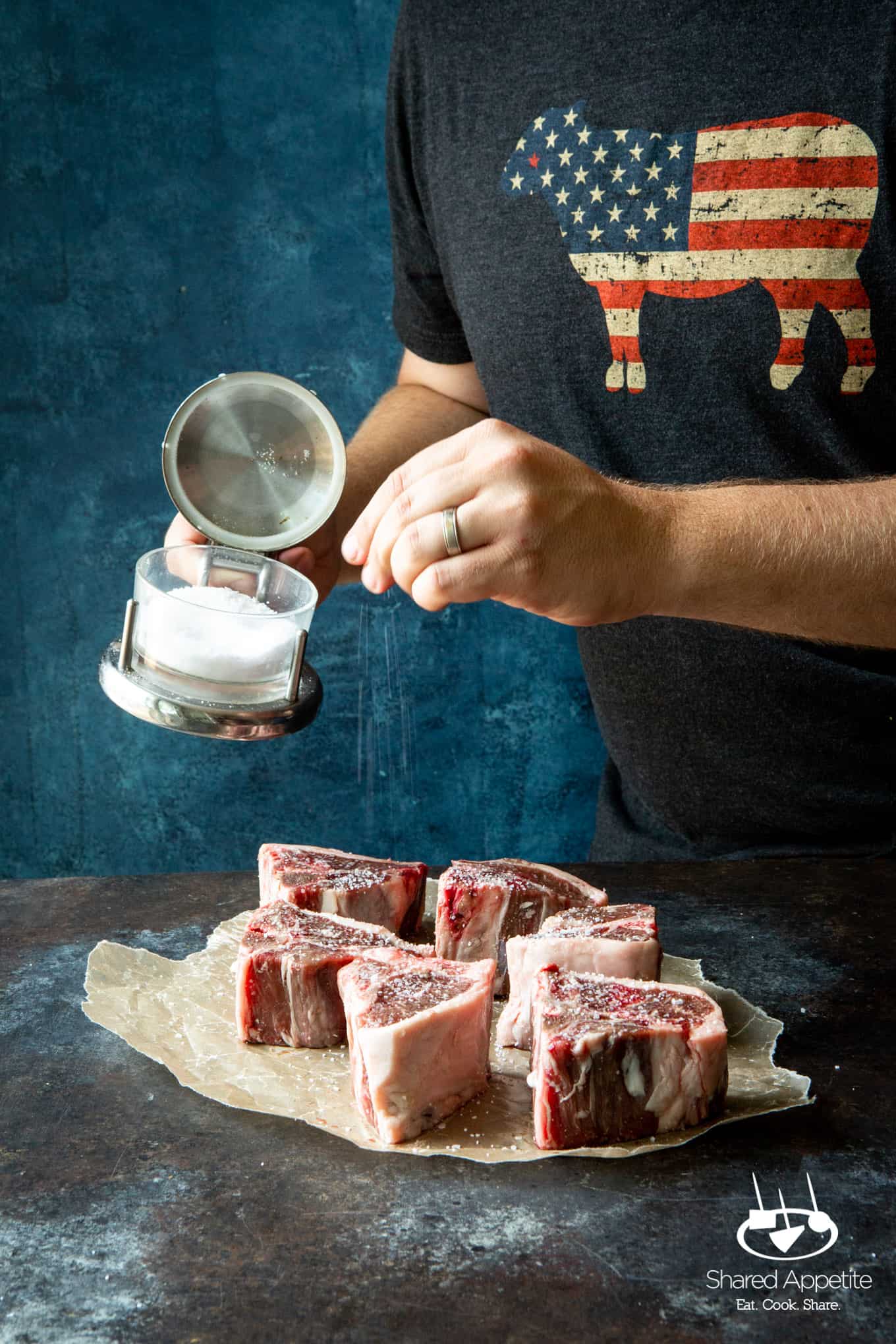 Sprinkling salt on lamb for Korean Lamb Chops with Grilled Scallions | sharedappetite.com