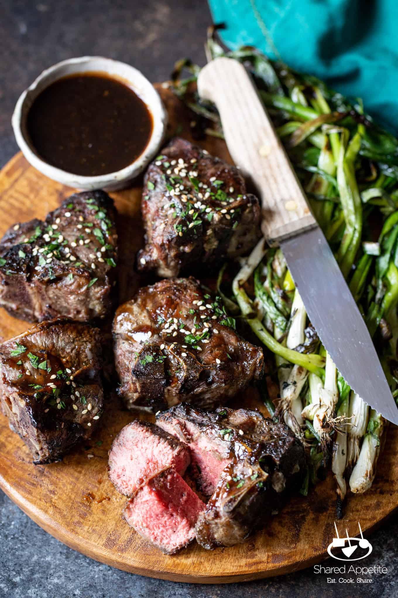 Cutting into a perfect medium-rare Korean Lamb Chops with Grilled Scallions | sharedappetite.com