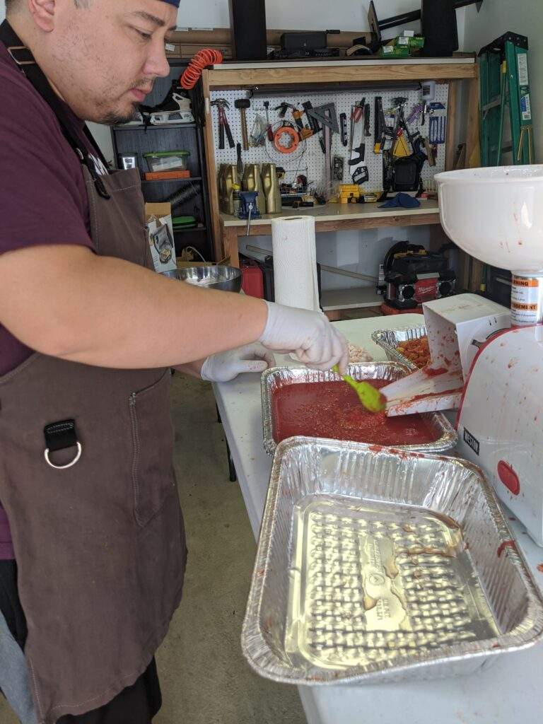 Steve running the tomatoes though a tomato strainer or food mill.